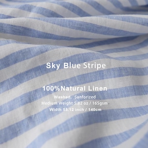May include: Sky blue and white striped linen fabric. The text on the fabric reads "Sky Blue Stripe" and "100% Natural Linen". The fabric is washed and sanforized, with a medium weight of 5.82 oz and a width of 55.12 inches.