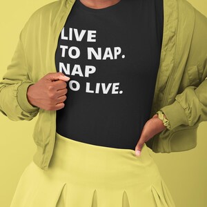 Könnte beinhalten: Ein schwarzes T-Shirt mit weißem Text, der "Live to nap. Nap to live." lautet.
