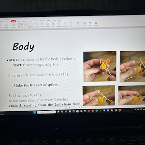 May include: A laptop screen displaying crochet instructions with the word "Body" at the top. The instructions include steps for creating spikes. Several images illustrate the crochet process. Colorful yarn balls are visible in the background.