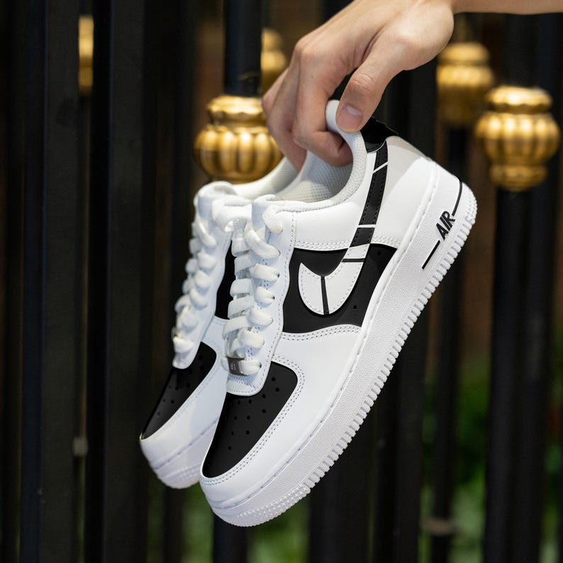 May include: White and black low-top sneakers with a black swoosh and the word "AIR" on the side.