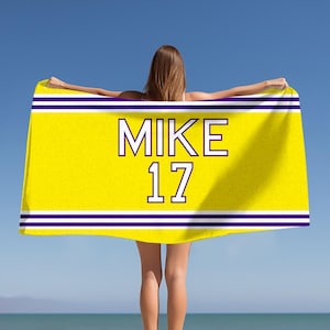 May include: Yellow beach towel with two purple stripes and the text "MIKE 17" in black.
