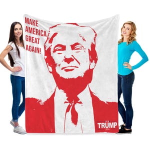 May include: White fleece blanket with a red silhouette of Donald Trump's face and the text "Make America Great Again!" and "Trump 2024".