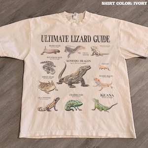 Op de afbeelding: Ivoor kleurig t-shirt met een gedetailleerde "Ultimate Lizard Guide" afbeelding. Het ontwerp bevat illustraties van verschillende hagedissen, zoals de Komodovaraan, Kameleon en Leguaan. Het shirt is van het merk Comfort Colors.