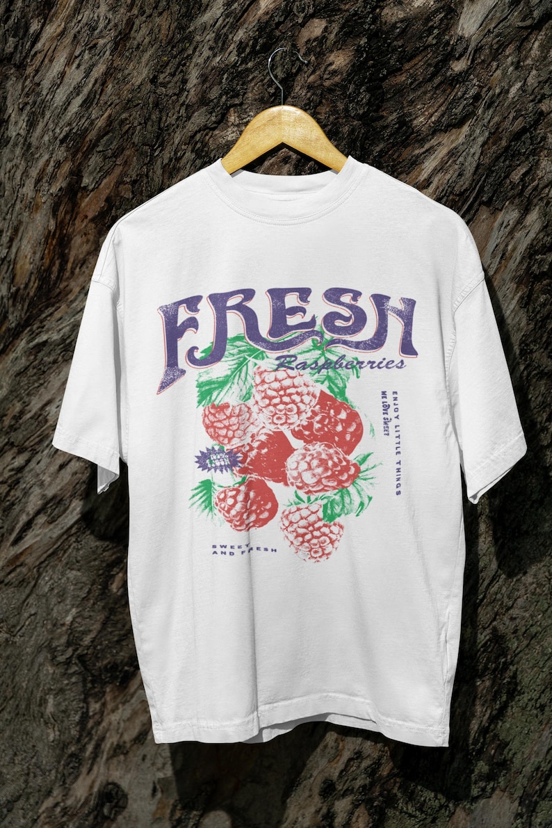 May include: White t-shirt with a graphic print of raspberries and the text "FRESH Raspberries Enjoy Little Things While They Last Sweet & Fresh & Tasty".