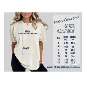 May include: Cream-colored t-shirt with a size chart. The chart lists sizes S to 4XL, with width and length measurements in inches. The text "Comfort Colors C1717" is at the top. The model is 5'2" and wearing a medium.