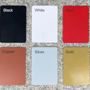 Six small square cards, each with a different color. The colors are black, white, red, copper, silver, and gold. The cards are arranged in two rows of three.