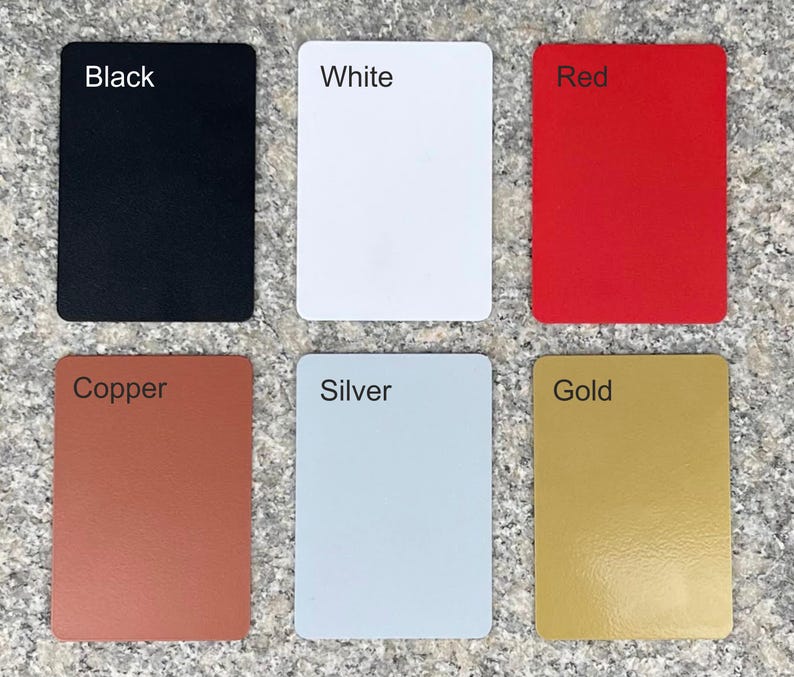 Six small square cards, each with a different color. The colors are black, white, red, copper, silver, and gold. The cards are arranged in two rows of three.