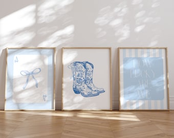 May include: Three framed prints with a blue and white color scheme. The left print features a blue bow on a light blue background. The center print features a pair of blue cowboy boots with floral designs. The right print features a blue and white striped background with the text "How lucky are we".