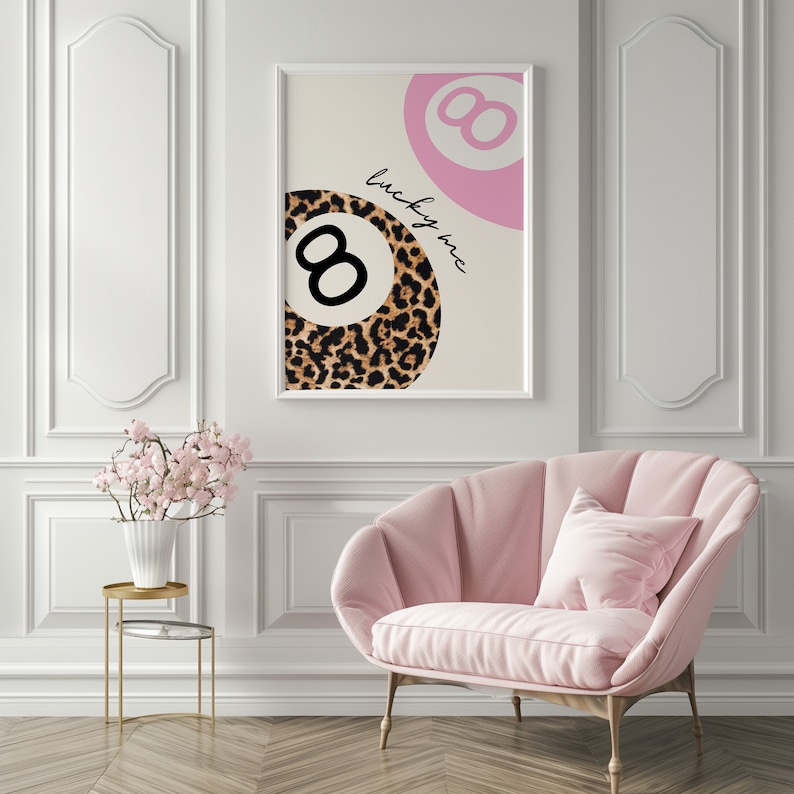 Puede incluir: Una impresi&oacute;n enmarcada en blanco con un dise&ntilde;o de bola 8 rosa y estampado de leopardo. El texto "lucky me" est&aacute; escrito en cursiva negra en la impresi&oacute;n.