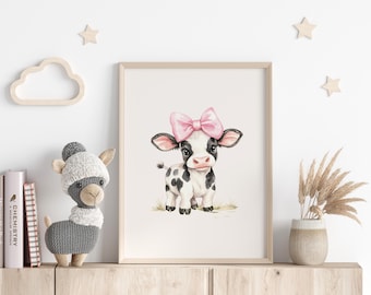 May include: A watercolor illustration of a black and white cow with pink bow, printed on a white background and framed in a light wood frame.