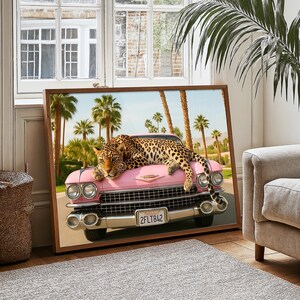 Puede incluir: Impresi&oacute;n enmarcada que presenta un coche rosa vintage con un leopardo descansando sobre el cap&oacute;. Palmeras y un cielo azul forman el fondo. La matr&iacute;cula dice "2FLT842".
