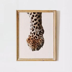 May include: A close-up of a leopard's paw with a diamond bracelet around the ankle. The paw is brown and black with spots and the bracelet is made of clear diamonds.