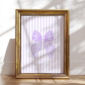 May include: A framed print with a purple bow on a white and purple striped background.