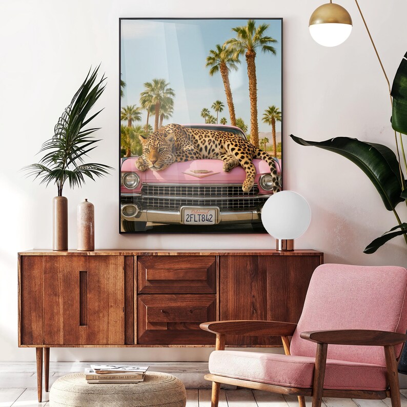 May include: A pink vintage car with a leopard lying on the bonnet. The car is parked in front of palm trees and a blue sky. The number plate reads "2FLT842".