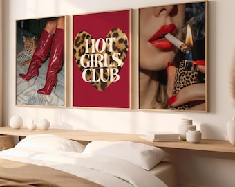 May include: Three framed prints with a red background. The center print features a leopard print heart with the text "HOT GIRLS CLUB". The print on the left shows a pair of red boots and a leopard print cat. The print on the right shows a woman's lips with red lipstick and a lit cigarette.