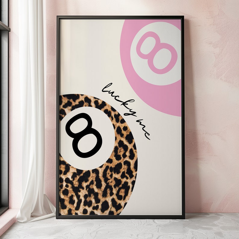 Puede incluir: Una impresi&oacute;n enmarcada en negro con fondo blanco que presenta una bola 8 rosa y de estampado de leopardo con el texto "lucky me" en cursiva negra.