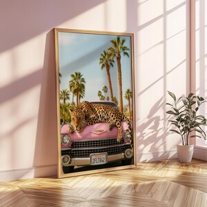 May include: A pink vintage car with a leopard lying on the bonnet. The car has a California number plate that reads "2FLT842". The car is parked in front of a palm tree lined street.