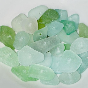Peut inclure: Un ensemble de perles en verre de mer dans des tons de vert et de bleu. Les perles sont lisses et ont un aspect givr&eacute;. Elles sont parfaites pour la fabrication de bijoux ou d'autres projets d'artisanat.