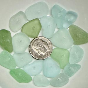 Peut inclure: Une collection de verre de mer dans des tons de vert et de bleu. Le verre de mer est dispos&eacute; dans un bol et comprend une pi&egrave;ce de 10 centimes pour l'&eacute;chelle.