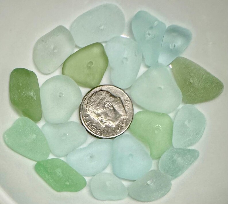 Peut inclure: Une collection de verre de mer dans des tons de vert et de bleu. Le verre de mer est dispos&eacute; dans un bol et comprend une pi&egrave;ce de 10 centimes pour l'&eacute;chelle.