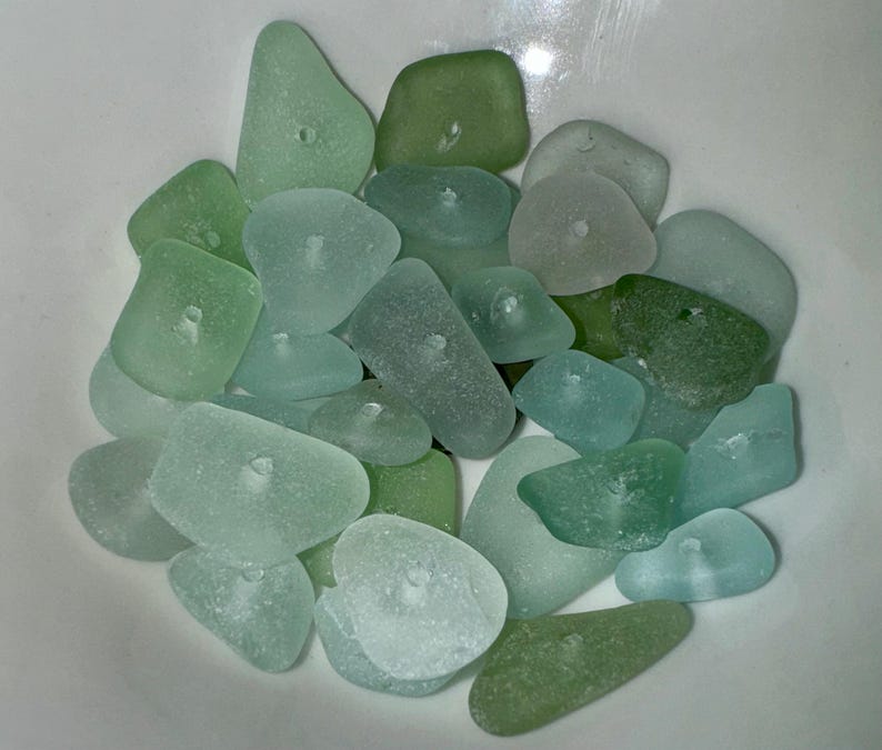 Peut inclure: Un bol de verre de mer dans diff&eacute;rentes nuances de vert et de bleu. Le verre est lisse et poli, avec une vari&eacute;t&eacute; de formes et de tailles.