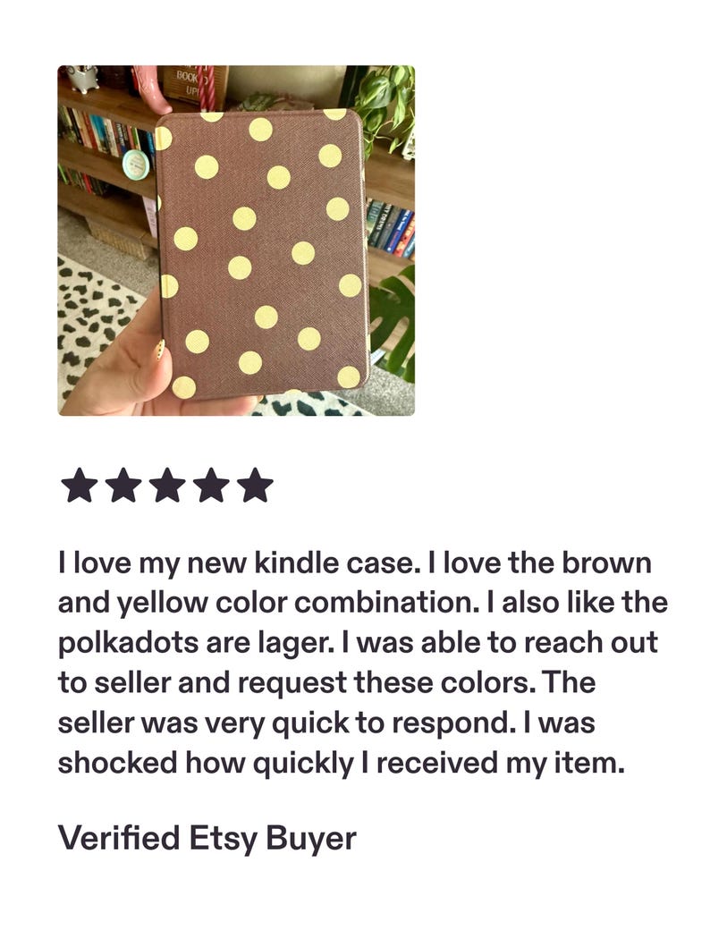 May include: A rectangular e-reader case featuring a brown base color with a repeating pattern of large, light yellow circular polka dots. The case has a textured surface and a slim, flat profile designed to protect a handheld electronic device.