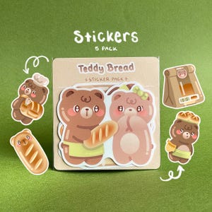 May include: A pack of five stickers featuring cute teddy bear characters with bread. The stickers include a bear holding a baguette, a bear with a bow, and a bear wearing a chef's hat. The text "Teddy Bread" and "Sticker Pack" are visible.