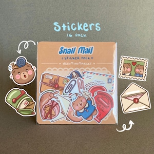 May include: A 16-pack of stickers with a snail mail theme. The stickers feature illustrations of mailboxes, envelopes, stamps, and a bear character. The packaging reads "Snail Mail" and "Veis Mini Market".