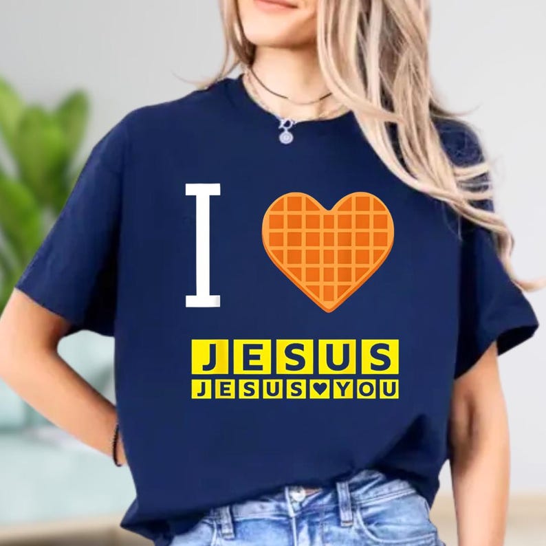 A woman wearing a navy blue t-shirt with a heart-shaped waffle and the text "I ♥ JESUS JESUS YOU" printed on it.