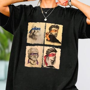 a person wearing a black t-shirt with four square images of different men, each with distinct facial expressions and hairstyles.