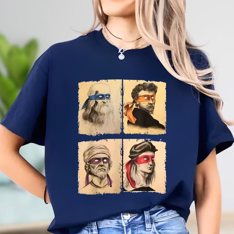 A woman wearing a blue t-shirt with four different portraits of men, each with distinct facial expressions and hairstyles.