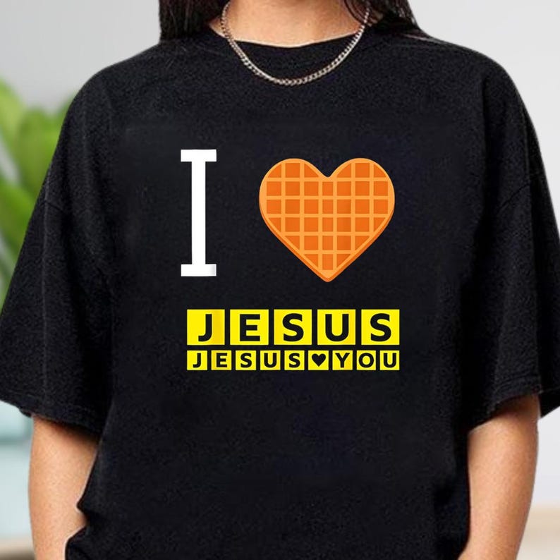 A black t-shirt with a graphic design featuring a heart-shaped waffle and the text "I ♥ JESUS JESUS YOU" printed on it.