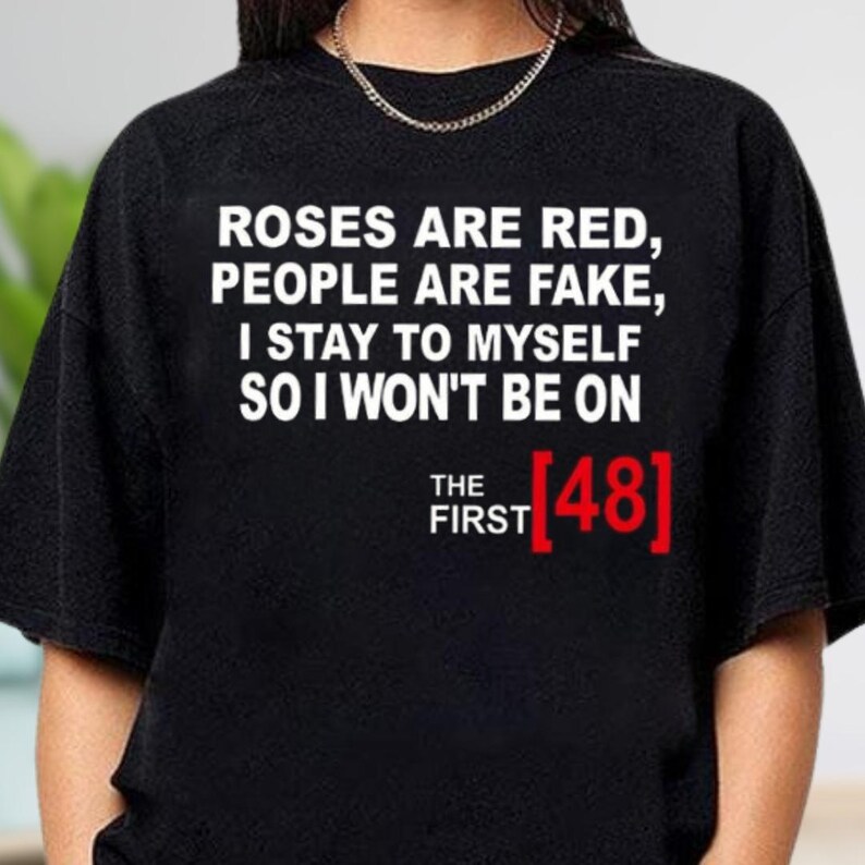 a black t-shirt with white text and a red number "48" on it.