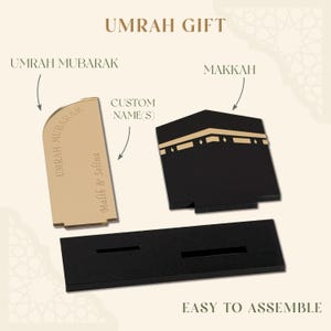 Op de afbeelding: Een goudkleurige Umrah Mubarak-plaquette en een zwart Kaaba-model met gouden accenten. De plaquette heeft de tekst "Umrah Mubarak" en een aangepaste naam. De tekst "Umrah Gift" en "Easy to Assemble" zijn ook zichtbaar.