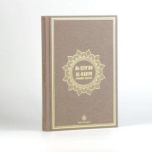 May include: A brown hardback book with gold lettering on the cover. The title is "Al-Qur'an Al-Karim" in Arabic and German. The book is published by Granada Verlag.