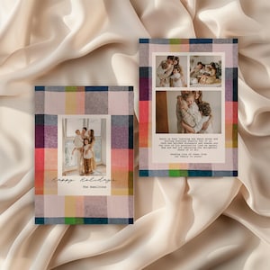 Two modern holiday photo cards with colorful plaid borders in pink, navy, green, yellow, and red are displayed on a soft, cream-colored fabric backdrop. The left card shows a single family portrait centered with handwritten text reading ‘Happy Holidays’ and ‘The Hamiltons.’ The right card features a collage of three family photos above a printed holiday message. The overall look is warm, cozy, and festive with a clean, contemporary design.