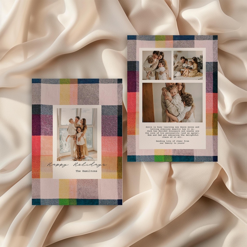 Two modern holiday photo cards with colorful plaid borders in pink, navy, green, yellow, and red are displayed on a soft, cream-colored fabric backdrop. The left card shows a single family portrait centered with handwritten text reading ‘Happy Holidays’ and ‘The Hamiltons.’ The right card features a collage of three family photos above a printed holiday message. The overall look is warm, cozy, and festive with a clean, contemporary design.