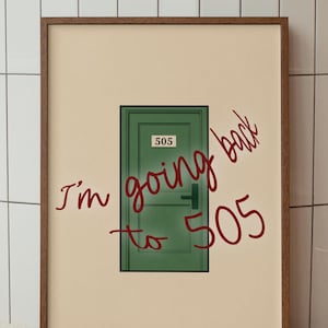 May include: A framed print with a green door illustration, the number 505, and the handwritten text "I'm going back to 505" in red. The artwork is set against a neutral backdrop.