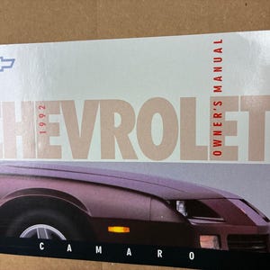 May include: A 1992 Chevrolet Camaro owner's manual with a red and white logo and a photo of a maroon Camaro on the cover.