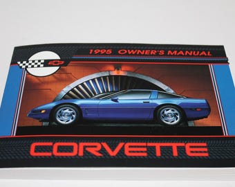 May include: A 1995 Corvette Owner's Manual with a blue Corvette on the cover. The cover has a black and white checkered flag, a Chevrolet logo, and the text "Corvette" in red.