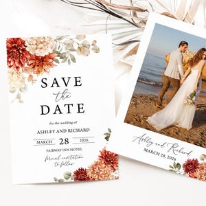 以下が含まれることがあります： 2 つの結婚式の招待状。1 つのカードには「Save the Date」と書かれており、Ashley と Richard の名前、2026 年 3 月 28 日の日付、花のアクセントが書かれています。もう 1 つのカードには、ビーチにいるカップルの写真と、Ashley と Richard の名前、2026 年 3 月 28 日の日付が書かれています。