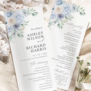 May include: Two wedding ceremony programs with floral decorations. The programs display the names Ashley Wilson and Richard Harris, plus the wedding date and time. The design incorporates blue and white flowers and green foliage.