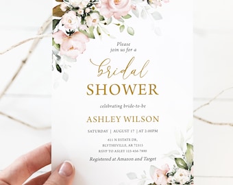May include: A white bridal shower invitation with floral accents. The invitation features the words "Bridal Shower" in gold script, along with the bride's name, date, and time. Floral arrangements in pink and white adorn the corners.