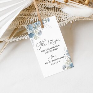 May include: A white thank you card with blue watercolour flowers. The text reads "Thank you for sharing our special day! Love, Ashley and Richard 03|28|2026".
