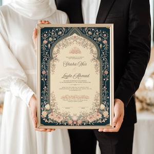 May include: A framed wedding certificate featuring intricate floral and scroll designs in teal, cream, and gold. The certificate displays the names "Shaha Nur" and "Layla Ahmad" in elegant script, and Arabic text.