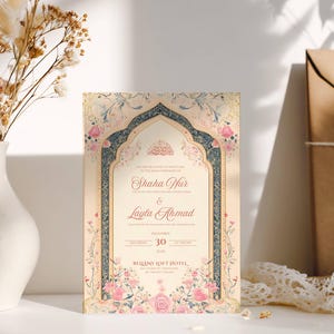 May include: An ornate wedding invitation with floral and archway designs. The invitation features the names "Shaha Nur" and "Layla Ahmad", along with the date December 30th. The invitation is surrounded by a white vase with dried flowers and a brown envelope.