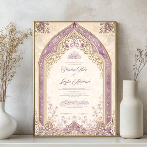May include: Framed wedding invitation with a gold border, featuring a purple and gold arched design. The invitation includes the names Shaha Nur and Layla Ahmad, with floral accents and Arabic script.