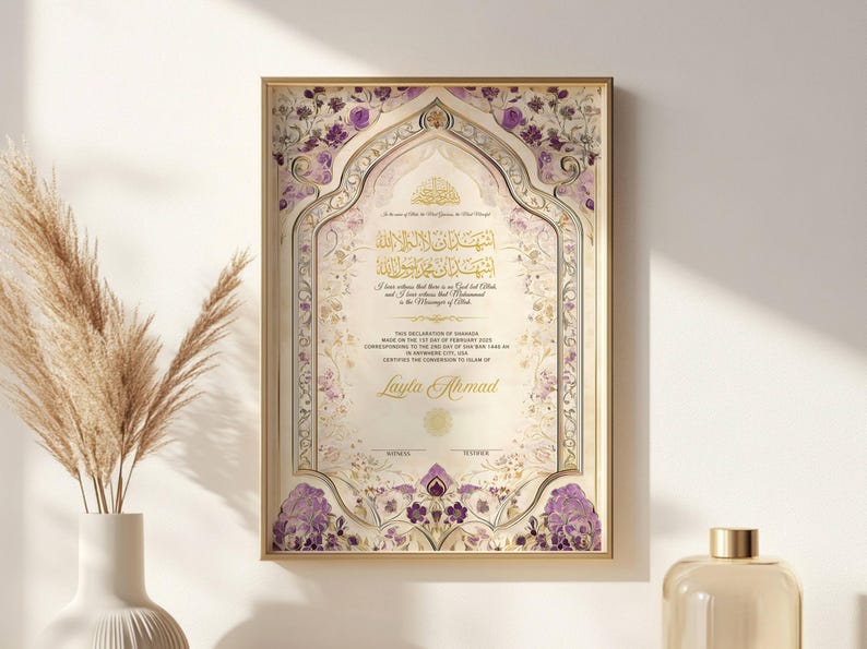 May include: A framed certificate with ornate floral and scrollwork designs in gold, cream, and purple. The certificate features Arabic calligraphy and the name "Layla Ahmad" in elegant script. The frame is gold.