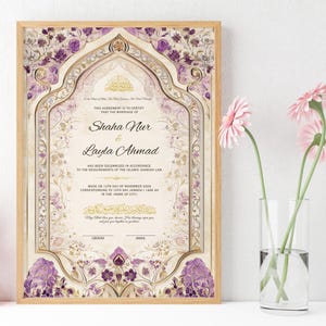 May include: A framed marriage certificate with ornate floral and geometric designs in purple and gold. The names "Shaha Nur & Layla Ahmad" are displayed prominently. A vase of pink flowers sits to the right.