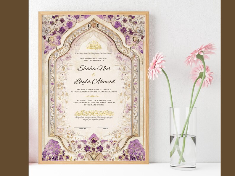 May include: A framed marriage certificate with ornate floral and geometric designs in purple and gold. The names "Shaha Nur & Layla Ahmad" are displayed prominently. A vase of pink flowers sits to the right.
